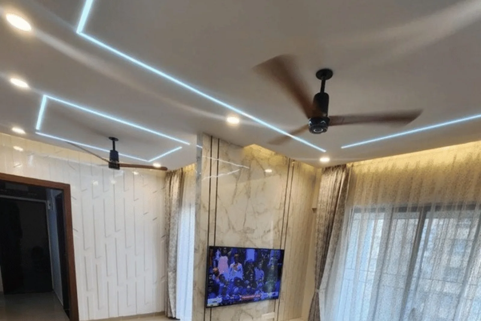 Marble-clad TV unit with wooden frame and cove-lit ceiling — 3 BHK turnkey, VTP Leonara, Kharadi